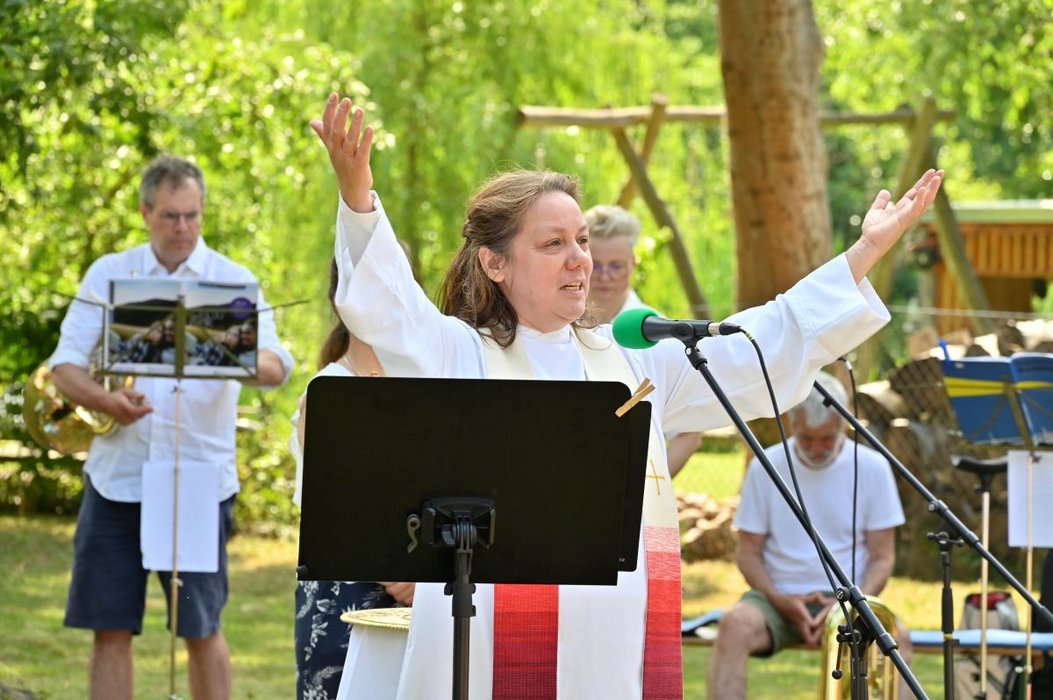 Frua im weißen Talar, dahinter Musiker mit Notenständer