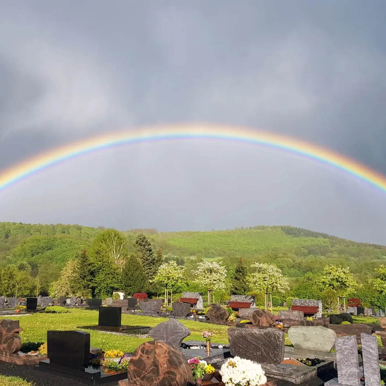 Ein Regenbogen der sich über dem Friedhof von Gemünden erhebt.
