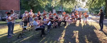 Menschen mit Posaunen und anderen Blasinstrumenten spielen im Freien